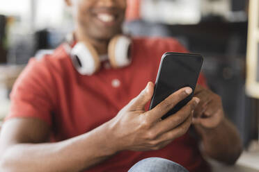 Hände eines Geschäftsmannes, der ein Smartphone im Büro benutzt - JCICF00303