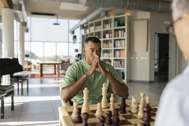 Geschäftsmann Hände verschränkt spielen Schachbrett im Büro - JCICF00357