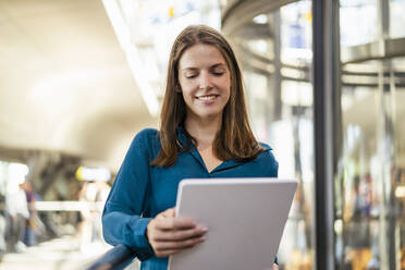 Lächelnde Geschäftsfrau mit Tablet-PC im Büro - DIGF18486