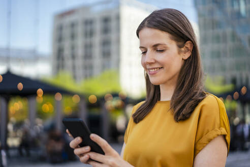 Geschäftsfrau Textnachrichten über ihr Smartphone - DIGF18498