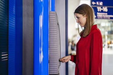 Geschäftsfrau beim Einführen der Karte am Geldautomaten - DIGF18514
