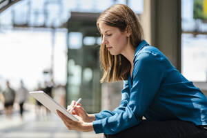 Geschäftsfrau arbeitet an einem Tablet-PC mit digitalisiertem Stift - DIGF18539