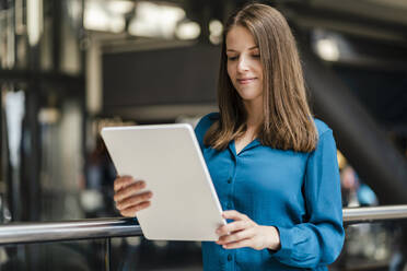 Businesswoman using tablet PC by railing - DIGF18542