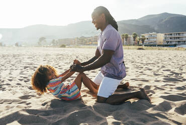 Father playing with daughter at beach - OIPF02233