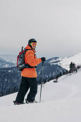 Skifahrer mit Skistock, der auf Schnee läuft - OMIF00999