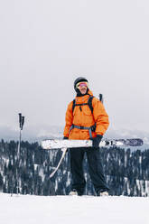 Mann mit Ski unter klarem Himmel stehend - OMIF01007