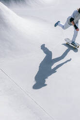 Man skateboarding in skate park on sunny day - OMIF01026