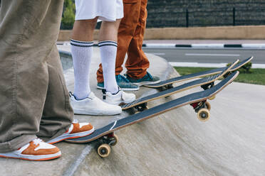 Beine von Freunden mit Skateboards im Park - OMIF01028