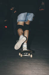 Frau beim Skateboardfahren im Park bei Nacht - OMIF01030