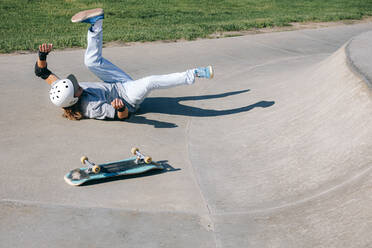 Mann mit Skateboard stürzt im Park - OMIF01031