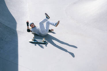 Sturz eines Skateboarders im Skatepark an einem sonnigen Tag - OMIF01036