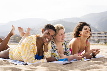 Happy multiracial friends lying down at beach on vacation - OIPF02242