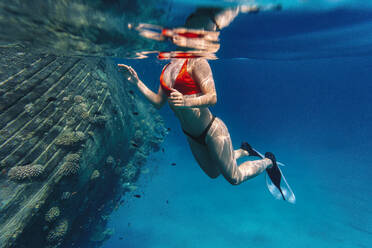 Frau schwimmt unter Wasser im Meer - KNTF06746