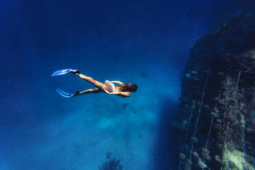 Adventurous woman diving underwater in sea - KNTF06753