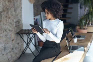 Junge Geschäftsfrau mit Tablet-PC auf dem Schreibtisch im Büro - JSRF02158