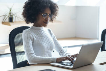 Junge Geschäftsfrau arbeitet am Laptop im Büro - JSRF02164
