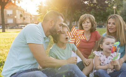 Familie spielt mit Windrädern im Park - JCCMF06806