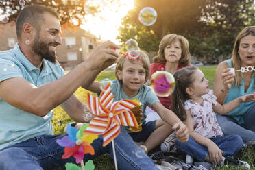 Familie bläst Seifenblasen im Park - JCCMF06808