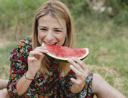 Lächelnde Frau isst Wassermelone im Park - JCCMF06837