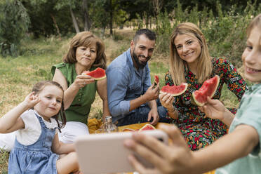 Lächelnder Junge macht Selfie mit Familie im Park - JCCMF06844