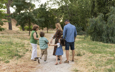 Family walking together on dirt road - JCCMF06853