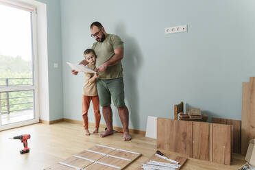 Vater und Sohn lesen zu Hause das Handbuch - OSF00537