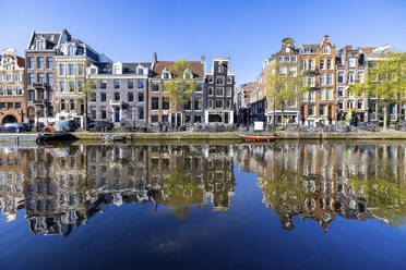 Niederlande, Nordholland, Amsterdam, Reihenhäuser, die sich auf der Wasseroberfläche eines Kanals spiegeln - WPEF06262