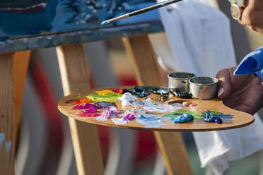 Hand eines Malers, der eine Palette mit Ölfarben hält - IHF01081