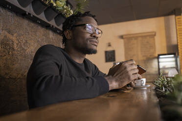 Thoughtful man with eyeglasses in cafe - OSF00549