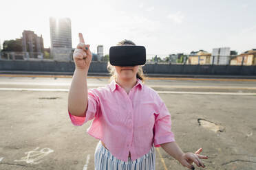 Teenage girl with VR goggles gesturing on street - MEUF07389