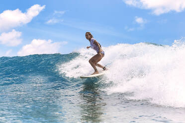 Woman surfing on surfboard in sea - KNTF06768