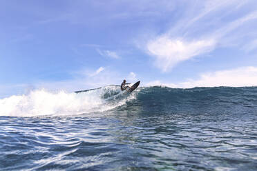 Surfer surft auf einer Welle, die im Meer plätschert - KNTF06770