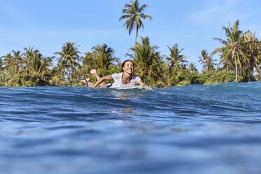 Lächelnde Frau genießt das Surfen auf dem Meer - KNTF06772
