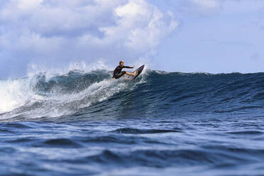 Mann balanciert auf Surfbrett auf Wellen im Meer - KNTF06781