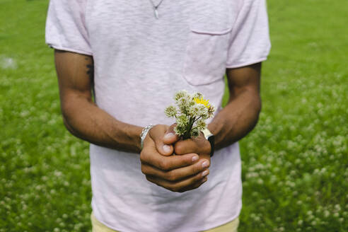 Mann hält Blumenstrauß im Park - SEAF01136
