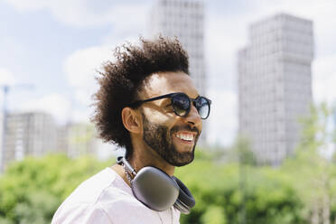 Happy man with headphones wearing sunglasses - SEAF01137