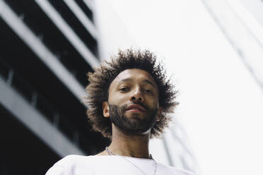 Bearded man with curly hair near building - SEAF01143