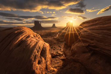 Atemberaubende Landschaft von Butte Felsformationen im Hochland mit Pfad während des Sonnenuntergangs in Monument Valley Navajo Tribal Park, Utah Arizona in USA - ADSF36081