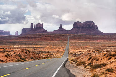 Atemberaubende Landschaft von Butte Felsformationen mit bewölktem Himmel in zwischen Asphalt Highway in Monument Valley Navajo Tribal Park, Utah Arizona in USA - ADSF36085