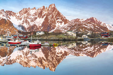 Fischerboote und schneebedeckte Berge spiegeln sich im Fjord bei Sonnenaufgang, Ballstad, Vestvagoy, Lofoten, Norwegen, Skandinavien, Europa - RHPLF22572
