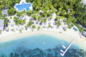 Canoes floating in the tropical lagoon of luxury resort with swimming pool on palm fringed beach, Antigua, West Indies, Caribbean, Central America - RHPLF22574