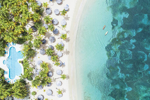 Kanus schwimmen im kristallklaren Meer mit Blick auf einen tropischen Sandstrand mit Swimmingpool, Antigua, Westindien, Karibik, Mittelamerika - RHPLF22576