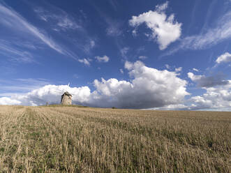 Windmühle in einem abgeschnittenen Feld mit blauem Himmel mit weißen Wolken, Normandie, Frankreich, Europa - RHPLF22624