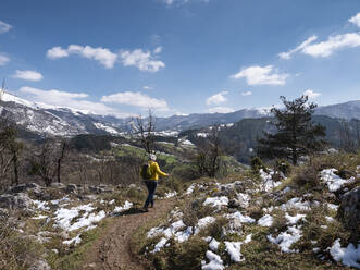 Ältere Frau mit Wanderstöcken auf einem Wanderweg - LAF02776