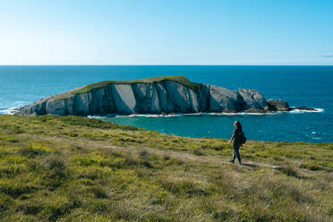 Asian girl hiking along the coast in Spring during the sunset - ADSF36111