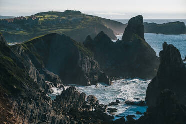 Scenic view of sea and mountains with houses on cliff in distant - ADSF36114