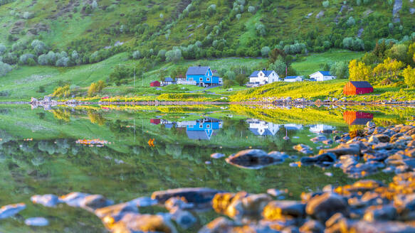 Norwegen, Nordland, Küstenlinie der Insel Vestvagoya mit abgelegenen Häusern im Hintergrund - STSF03376