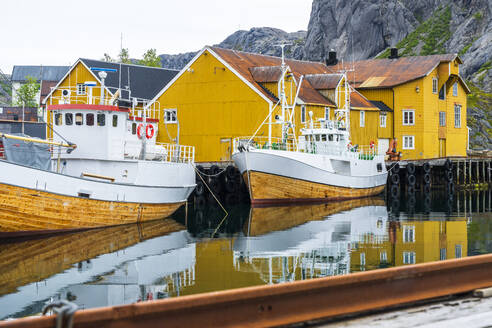 Norwegen, Nordland, Nusfjord, Fischerboote vor den Stelzenhäusern an der Küste - STSF03391