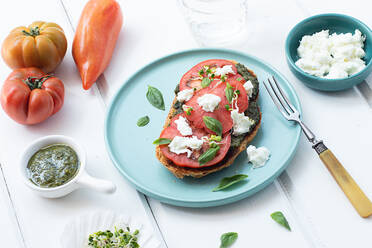 Draufsicht auf Caprese-Toast, serviert auf einem Holztisch - ADSF36155