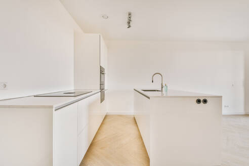 Interior of empty open plan white kitchen and wooden parquet floor - ADSF36192